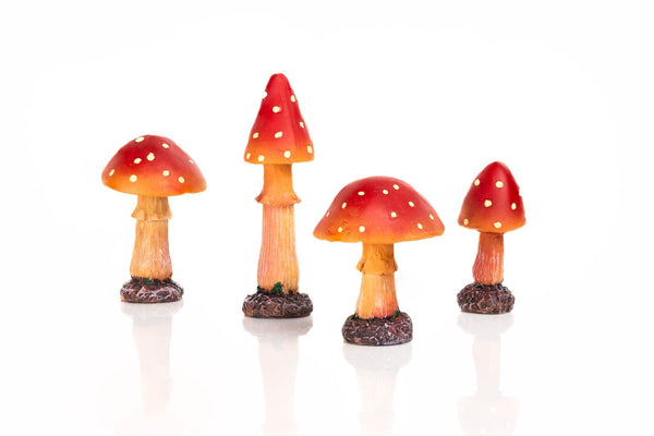 Red garden fungi ornaments displayed beside flowers