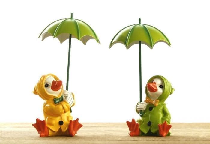 Duck family garden ornaments wearing colourful raincoats