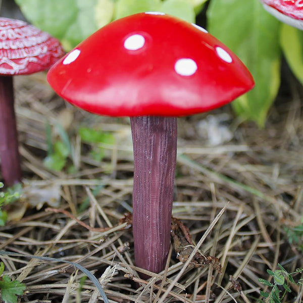 Weatherproof mushroom ornaments positioned in a flower bed