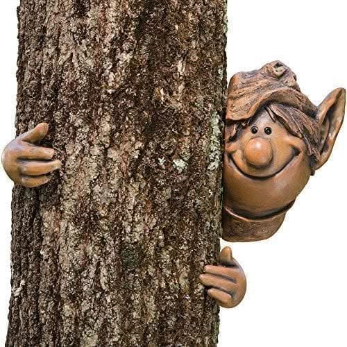 Garden elf figure peeking around tree
