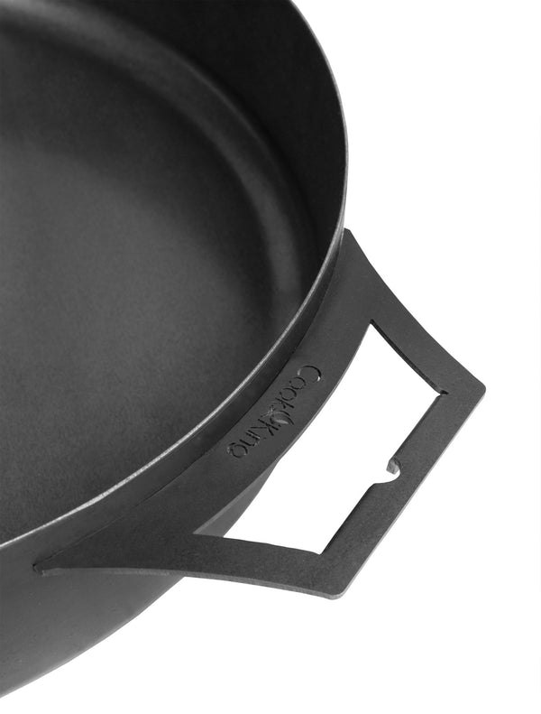 Black cast iron skillet with a handle on a white background