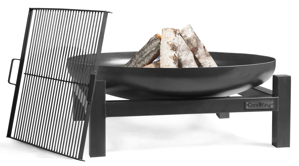 A black steel fire bowl with wood burning inside, supported by a metal frame, on a white background.