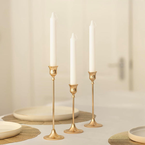 Modern gold candle holders with white taper candles