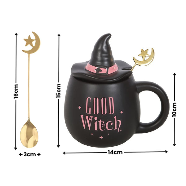 Black witch-themed ceramic mug with a pointed hat lid, pink 'Good Witch' text, and a gold spoon with a crescent moon and star handle, shown with height and width dimension callouts on a white background.