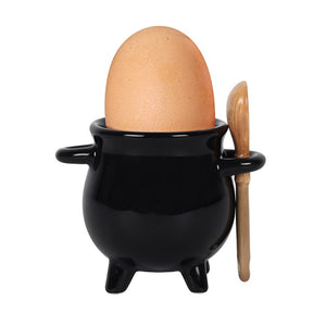 Black cauldron-shaped egg holder with a wooden spoon on a white background
