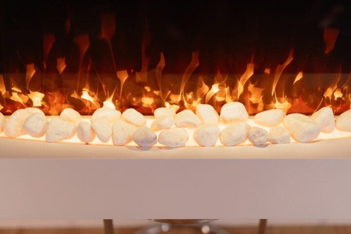 white-wall-mounted-electric-fireplace-with-pebbles